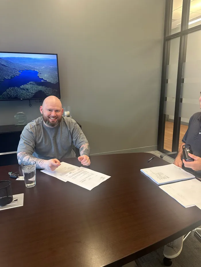 Coty at his closing table, signing his home paperwork